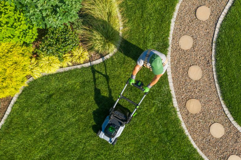 overview of landscaper mowing lawn and landscaping yard.